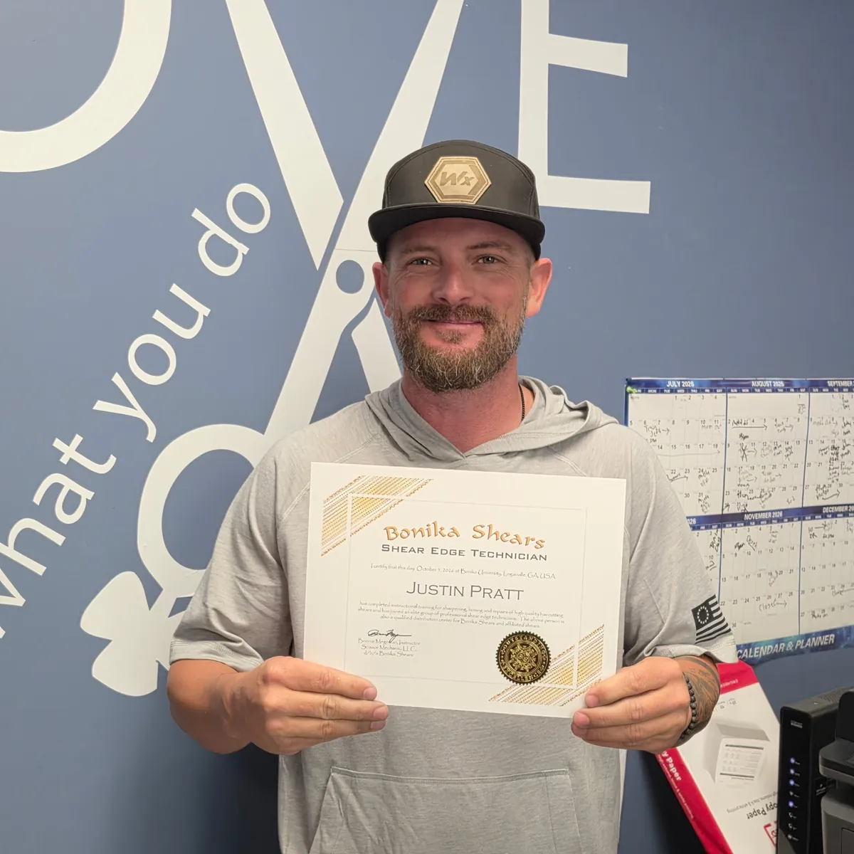 Justin Pratt holding his Bonika Shears Shear Edge Technician certificate